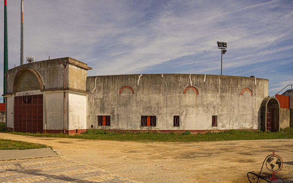 Außenansicht der Stierkampfarena mit geschwungenem Betonbau und rotem Torbogen