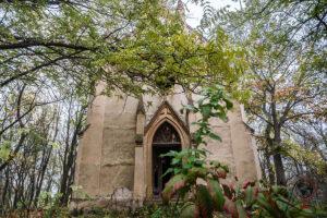 Bezerédj-Kapelle in Hídjapuszta bei Szedres, Ungarn, mit von Bäumen überwachsener neogotischer Fassade und spitzbogigem Eingang