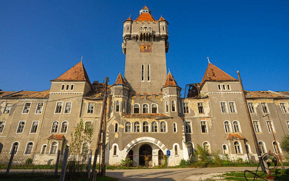 Außenansicht der verlassenen Kaserne in Hajmáskér mit hohem Turm und rotem Ziegeldach