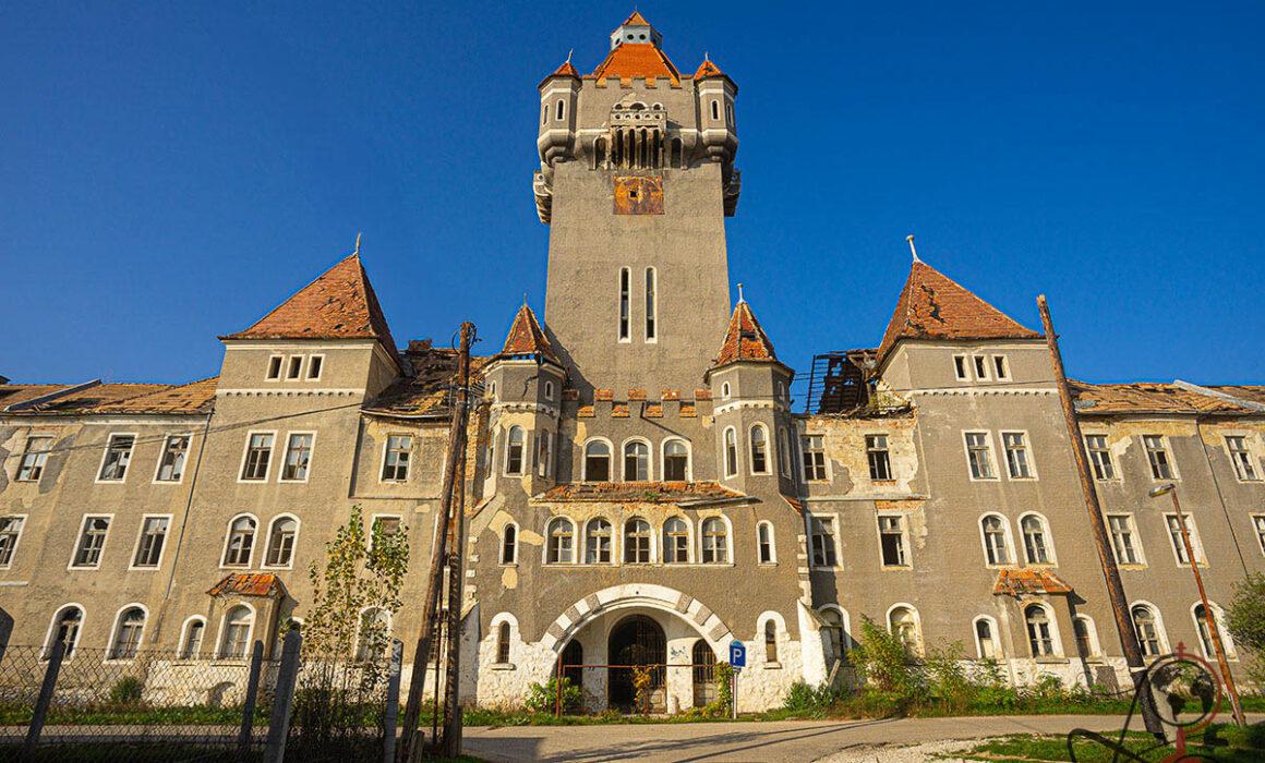 Außenansicht der verlassenen Kaserne in Hajmáskér mit hohem Turm und rotem Ziegeldach