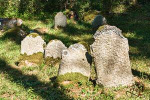 Umgestürzte und zerbrochene Grabsteine im Wald auf dem jüdischen Friedhof Pořejov