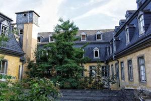 Innenhof des ehemaligen Klosters Marienberg in Boppard mit verwitterten Gebäudefassaden und Bäumen