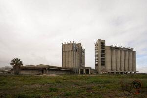 Verlassene Nutasa-Futtersilos in Barreiro mit hohen Betontürmen hinter verwildertem Gelände