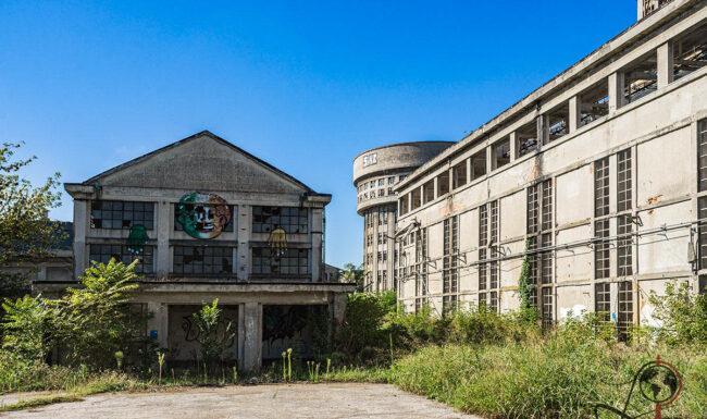 Außenansicht der ehemaligen Eridania-Destillerie in Ferrara mit dem Oculus Tower zwischen weiteren Fabrikgebäuden.