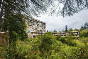 Panoramablick auf den begrünten Innenhof des Sanatoriums Samkurnalo mit überdachtem Durchgang und mehreren Gebäudeteilen