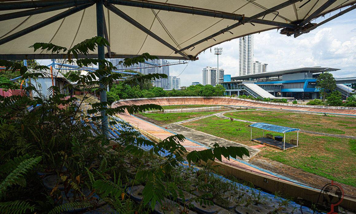 Blick über die überwucherten Tribünen auf die Bahn im Velodrom Pang