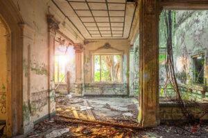 Innenraum mit Sonnenlicht, bröckelndem Putz und Fliesenband an den Wänden